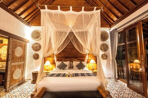 Una habitación con una cama bajo un dosel, paredes de madera, suelo estampado y platos decorativos.
