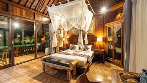 A wooden room with a bed, a bench, a table, and a balcony with a view. - Kasubatu (City)