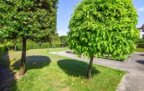 A well-maintained garden with mature trees, a paved walkway, and a clear sky. - 2 bedroom stunning home in Lido di Camaiore (Lido di Camaiore)