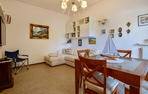 A dining area with a glass table, wooden chairs, a white sofa, and a bookshelf. - 2 bedroom stunning home in Lido di Camaiore (Lido di Camaiore)
