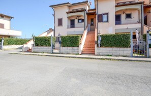 A residential building with a gated entrance, a staircase leading to the entrance, and a well-maintained hedge. - 3 bedroom stunning apartment in Pomonte (Pomonte)
