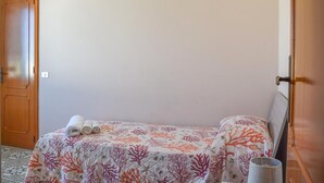 A room with a bed, a door, and a wall socket. - Beautiful apartment in Marina di Modica with WiFi (Marina di Modica)