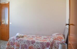 Ein Zimmer mit einem Bett, einer Tür und einer Steckdose.