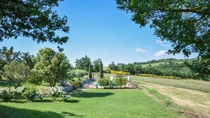 A lush green landscape with a pool area, trees, and a hilly background. - Gorgeous home in Fabro (Fabro)