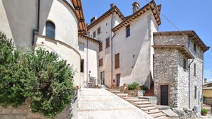 A traditional stone building with a staircase leading to a door, surrounded by other buildings. - Amazing apartment in Frazione Montebibico (Frazione Montebibico)