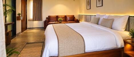 Un dormitorio espacioso con una cama grande, un sofá de cuero y un cabecero de madera.