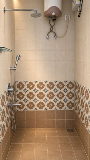 A shower area with a handheld showerhead, a wall-mounted showerhead, and a water heater.