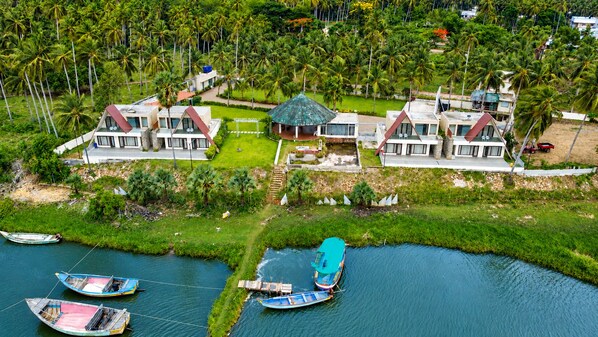 A residential area with houses, a river, and boats. - Rio Vista (Razole)