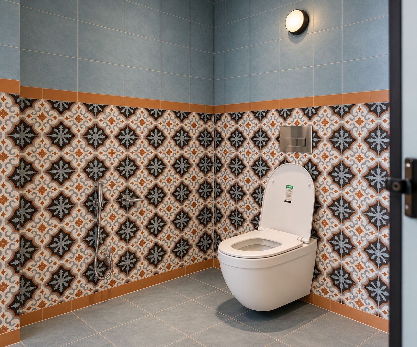 Une salle de bain avec un mur recouvert de carreaux à motifs, des toilettes et un luminaire.