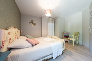 A bedroom with a bed, a dresser, a chair, and a wall decoration.