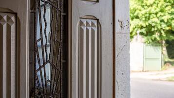 Un gros plan d’une porte ornée de motifs métalliques et d’une fenêtre à motifs géométriques.