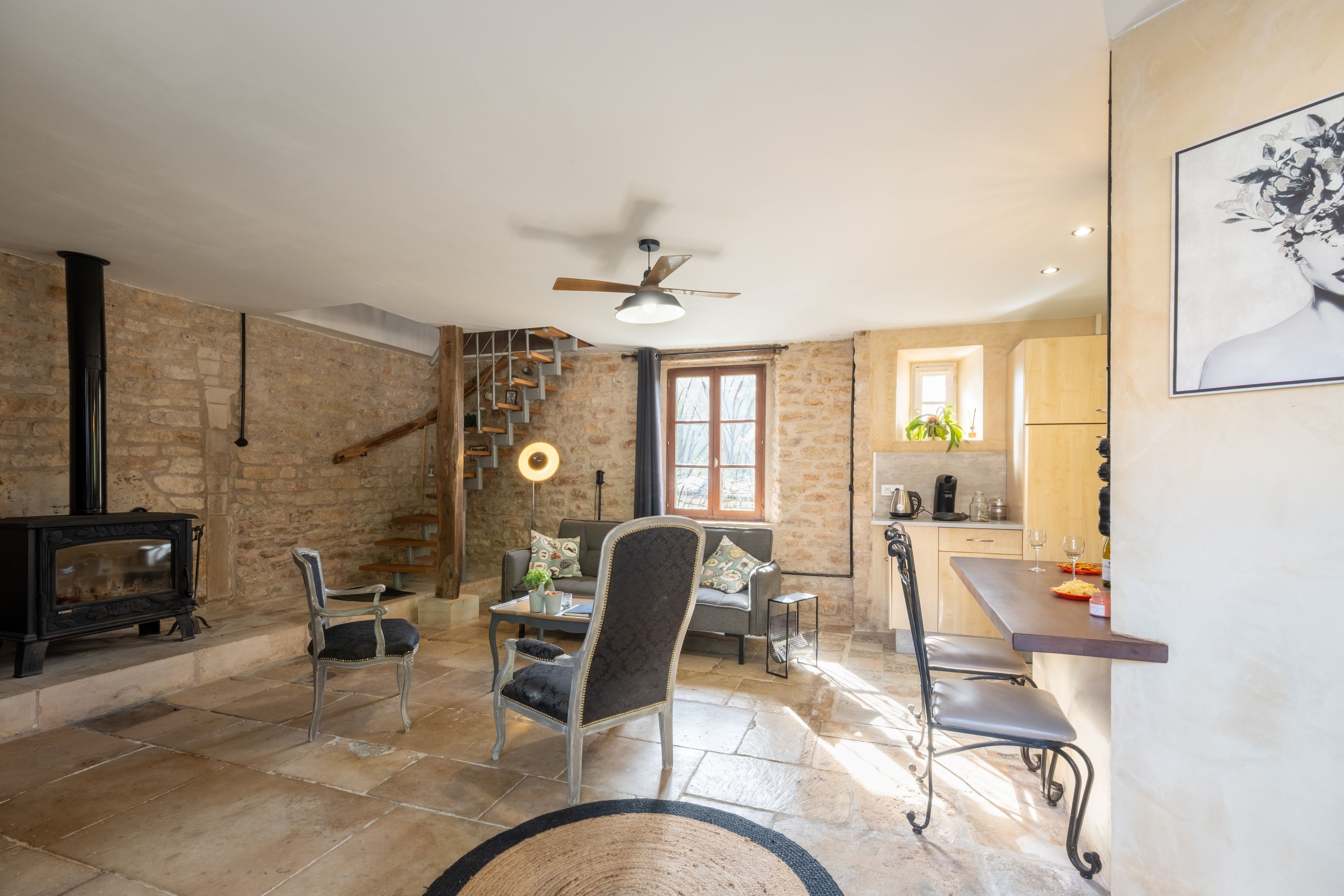 Un salon chaleureux avec une cheminée, un coin repas et une cuisine.