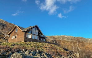 A modern house with a sloped roof, large windows, and a stone foundation. - Lovely home in Bjerkreim with WiFi (Bjerkreim)