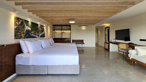 Une chambre d’hôtel avec un grand lit, un bureau avec une chaise, une télévision et un tableau au mur.