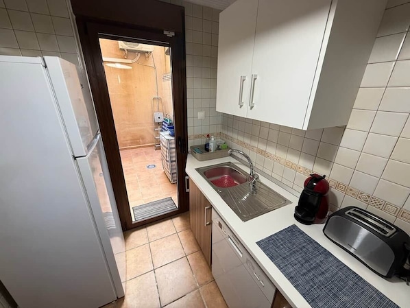 Eine kleine Küche mit Kühlschrank, Spüle und Toaster.