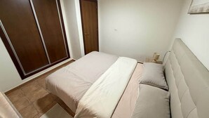 Un dormitorio con cama, armario y puerta.