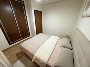 A bedroom with a bed, a wardrobe, and a door. - Felipe Beach Apartment (Los Cuarteros)