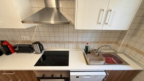 Ett kök med spis, brödrost, diskho och diskmaskin.