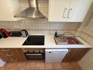 A kitchen with a stove, toaster, sink, and dishwasher. - Magdolina Beach Apartment (Los Cuarteros)