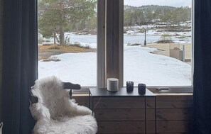 Ein Zimmer mit großem Fenster, weichem Teppich und Holzschrank.