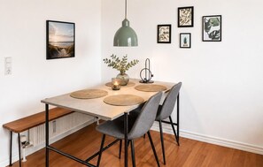 A dining area with a table, chairs, a pendant light, and framed botanical prints on the wall. - 3 bedroom amazing home in Hvide Sande (Hvide Sande)
