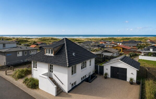 A residential area with houses, a clear sky, and a beach in the background. - 3 bedroom amazing home in Hvide Sande (Hvide Sande)