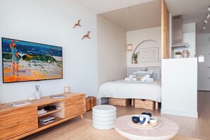 Ein modernes Hotelzimmer mit Bett, Nachttisch und einem großen Gemälde an der Wand.