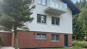 A modern two-story building with a flat roof, large windows, and a brick base. - Nice home in Wisla with house a mountain view (Wisla)