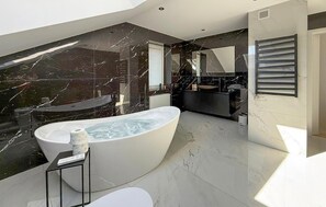 Une salle de bain moderne avec une baignoire sur pieds, des toilettes et un lavabo.