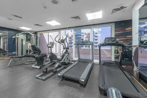 Ein Fitnessstudio mit Laufbändern, Crosstrainern und Gewichten.