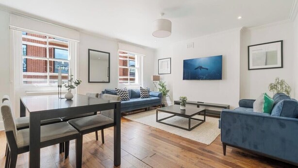 Ein modernes Wohnzimmer mit Esstisch, Sofa und Couchtisch.