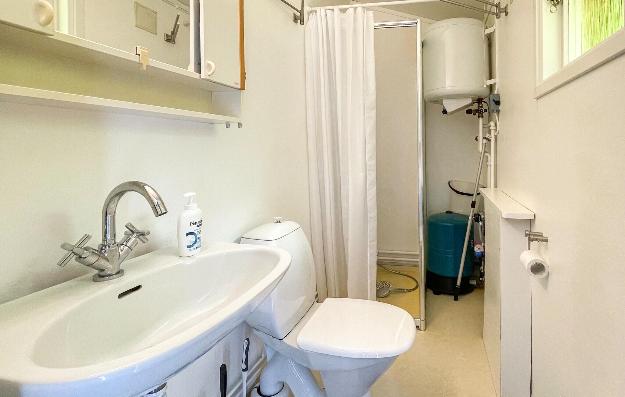 A bathroom with a sink, toilet, and a shower curtain.
