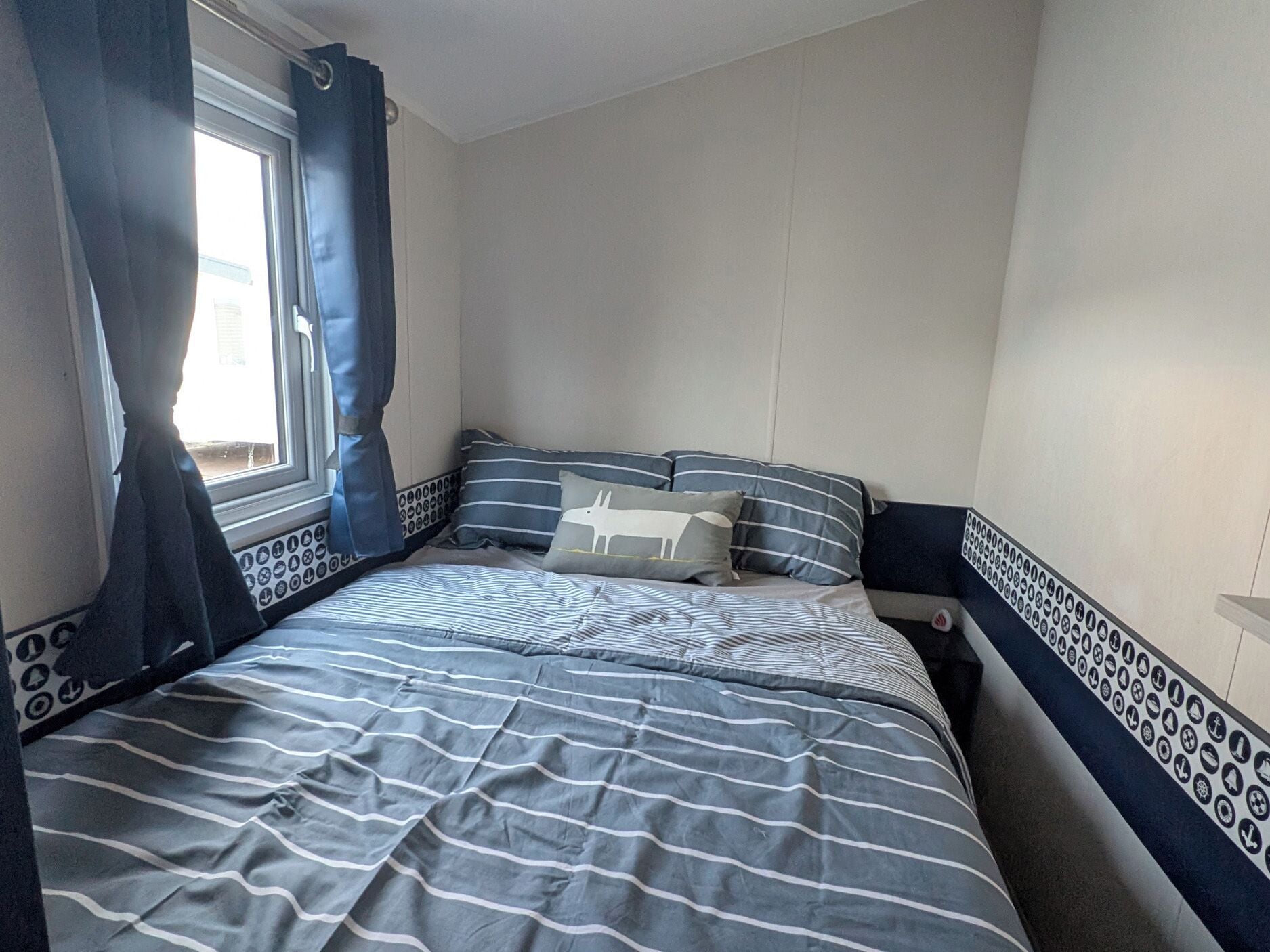 Un dormitorio con cama, cortinas y ventana.