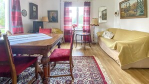 Un accogliente soggiorno con un tavolo da pranzo in legno, sedie rosse, un divano e un tappeto decorato.