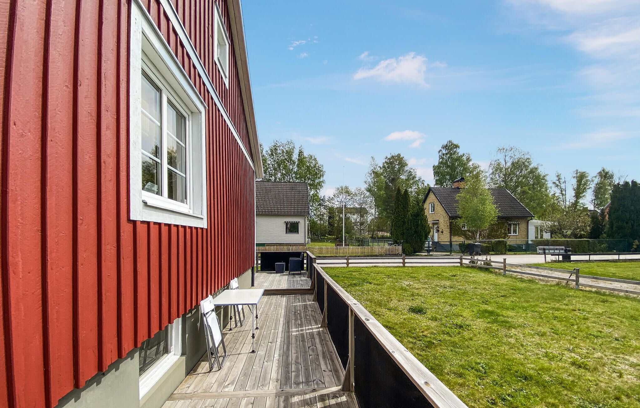 A red building with a wooden deck and a white window.