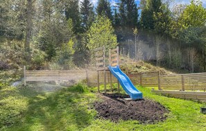 A playground with a blue slide and a wooden fence. - Pet friendly home in Broaryd with WiFi (Broaryd)