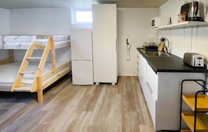 A compact kitchen with a refrigerator, microwave, toaster, and a sink.