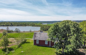 Ein Haus mit roter Backsteinfassade, geneigtem Dach und einer kleinen Veranda.