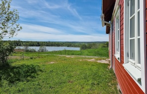 Ein Haus mit Blick auf einen See und Wald.