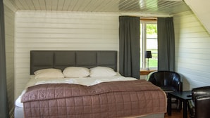 A bedroom with a bed, a chair, a desk, and a window with curtains. - 4 bedroom awesome home in Kopparberg (Kopparberg)