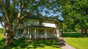 A two-story house with a porch, surrounded by trees and a well-maintained lawn. - 4 bedroom awesome home in Kopparberg (Kopparberg)
