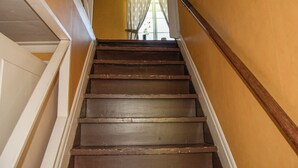 A wooden staircase with white trim, leading to a room with yellow walls and a window with curtains. - 4 bedroom awesome home in Kopparberg (Kopparberg)