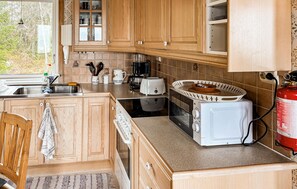 Eine Küche mit Holzausstattung, Spüle, Toaster, Wasserkocher und Feuerlöscher.