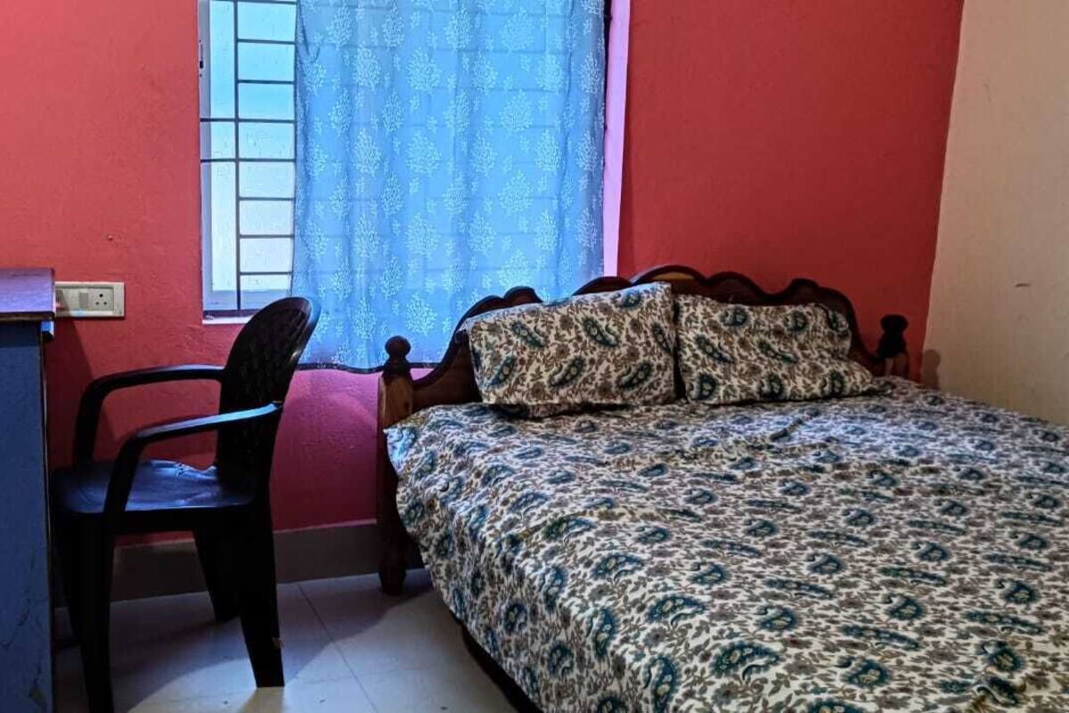 Una habitación con una cama, un escritorio y una silla.