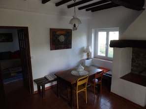 Un comedor con una mesa, sillas, una lámpara y un cuadro en la pared.