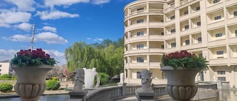 A hotel with a curved facade, a bridge, and flower pots.