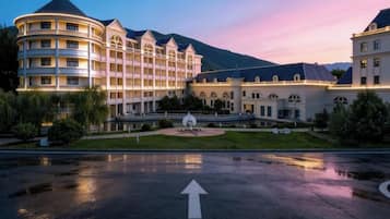Een hotel met een circulair gebouw, een fontein en een berg op de achtergrond.