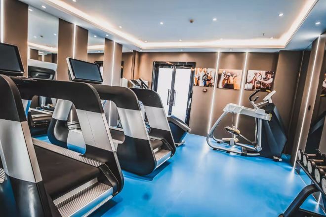 A modern gym with treadmills, stationary bikes, and a rowing machine.