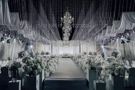 An indoor venue with a central aisle, draped fabric, and floral arrangements.. Old Tram Hotel