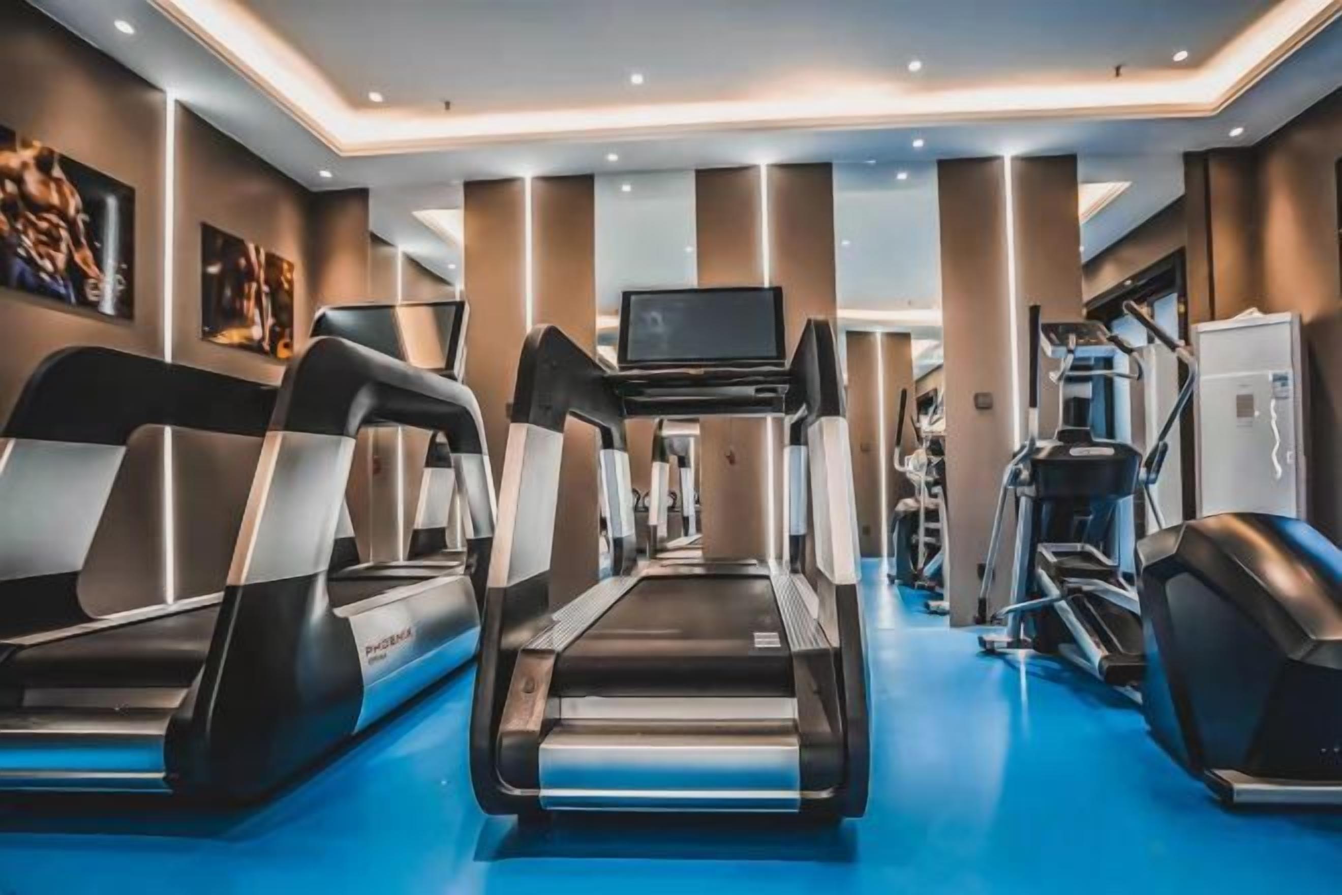 A fitness center with treadmills, a television, and exercise equipment.